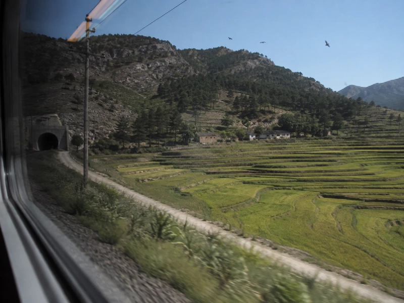 韓国の高速鉄道の車窓から見える、山あいの田園とトンネルが続く風景