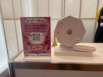白い八角形の抽選機と、QRコードを載せたピンクのPOP