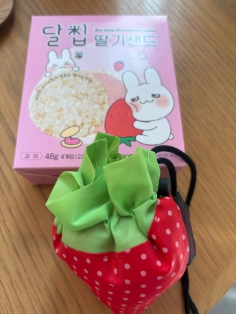 イチゴの形をしたエコバッグと、ピンクの箱に入ったイチゴ味のお菓子