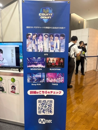 『M COUNTDOWN』のロゴと出演アーティストの写真、QRコードが入ったMnetの縦長バナー