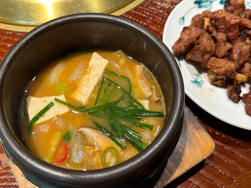 土鍋に盛られたテンジャンチゲと、焼き上がった豚カルビの皿