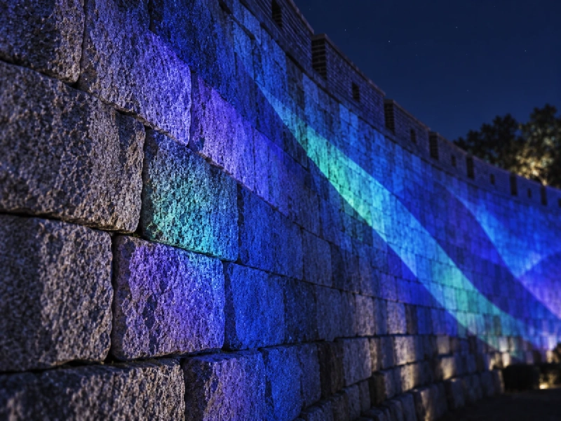 夜の韓国で、古い城郭の石垣に光の映像が広がる様子のイメージ